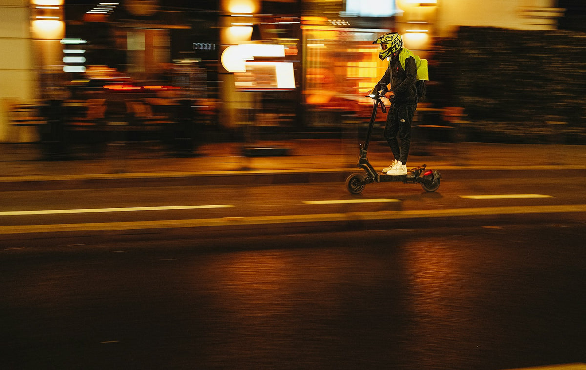 Trottinette électrique roulant de nuit sur une rue mouillée